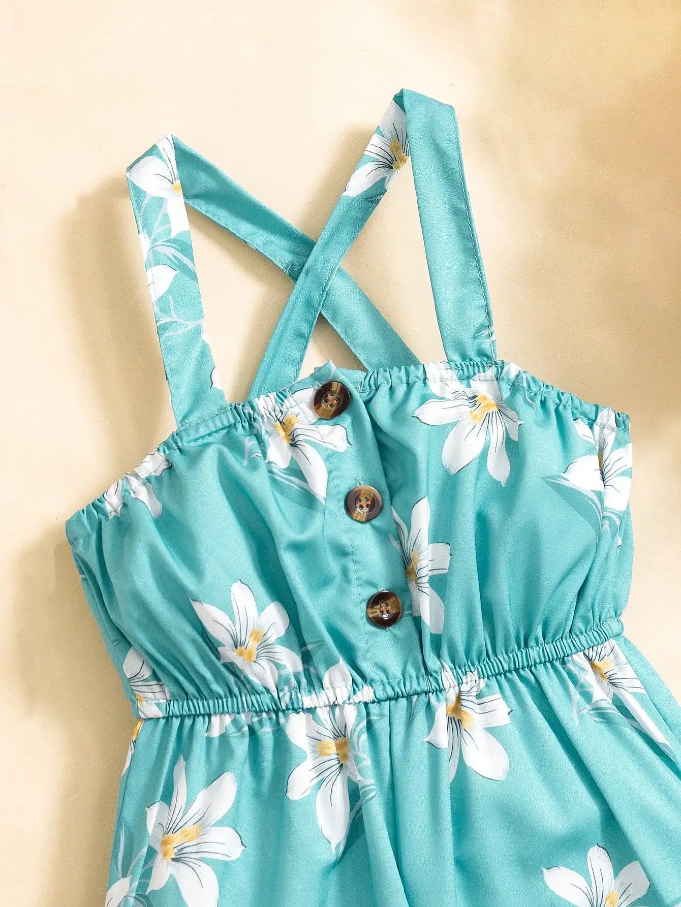 (6097) 夏と海辺の休暇にぴったりの、ロマンチックな小花柄サスペンダーロンパース。ボタン付きウエストとワイドレッグデザインが特徴。